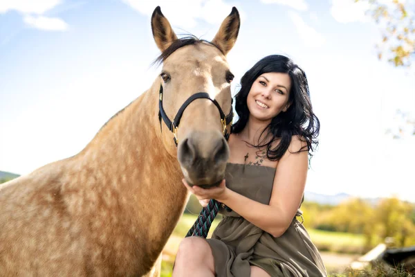 Un retrato de una joven hermosa mujer con caballo marrón al aire libre —  Fotos de Stock