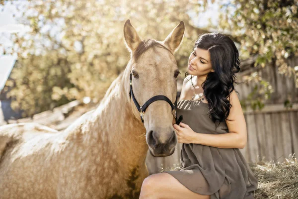 Um retrato de jovem mulher bonita com cavalo marrom ao ar livre — Fotografia de Stock