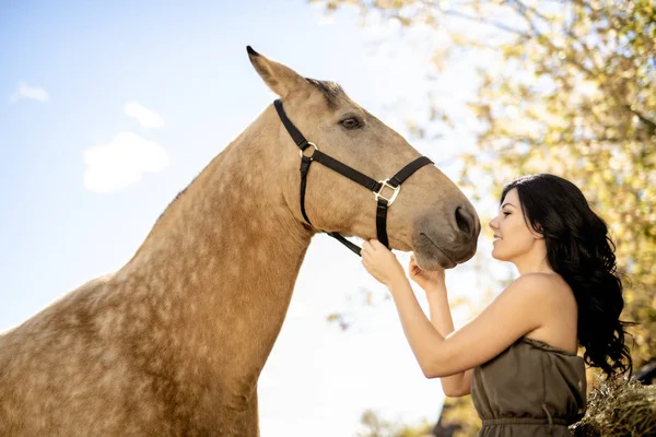 Um retrato de jovem mulher bonita com cavalo marrom ao ar livre — Fotografia de Stock