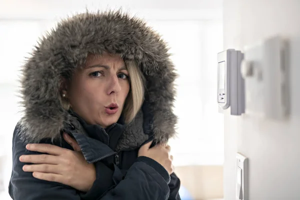 Femme avec des vêtements chauds sentant le froid à l'intérieur de la maison — Photo