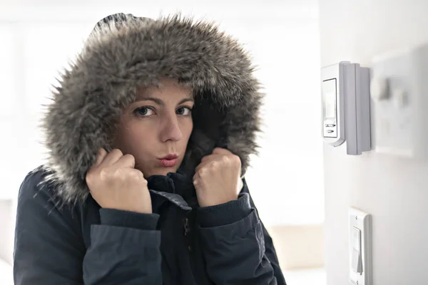 Femme avec des vêtements chauds sentant le froid à l'intérieur de la maison — Photo