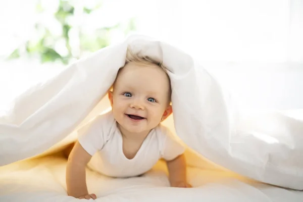 Linda niña acostada en sábana blanca en casa — Foto de Stock