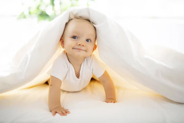 自宅の白いシートの上に横たわる女のかわいい赤ちゃん — ストック写真