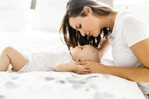 Madre con el bebé en la cama pasar un buen rato —  Fotos de Stock