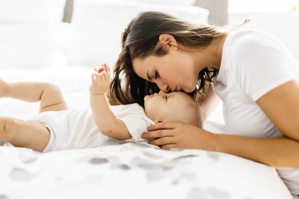 Mother with baby on bed having good time — Stock Photo, Image