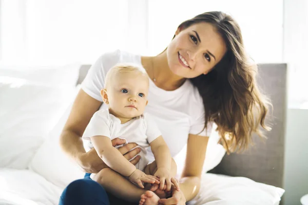 Mother with baby on bed having good time — Stock Photo, Image