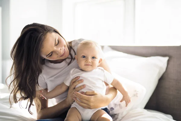 Madre con el bebé en la cama pasar un buen rato — Foto de Stock