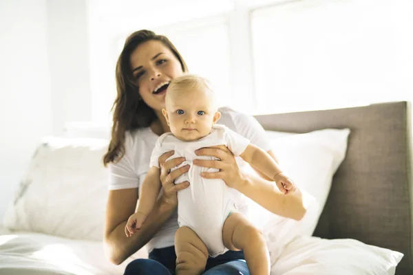 Mother with baby on bed having good time — Stock Photo, Image