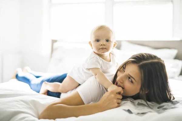 Mère avec bébé sur le lit avoir du bon temps — Photo