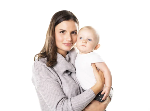 Una madre tiene il suo bambino sullo sfondo bianco dello studio — Foto Stock