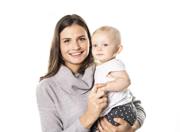 Uma mãe segurando seu bebê no estúdio fundo branco — Fotografia de Stock