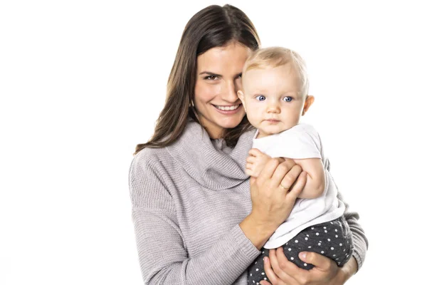 Una madre tiene il suo bambino sullo sfondo bianco dello studio — Foto Stock