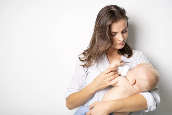 En mor holder sin baby på studie hvid baggrund - Stock-foto