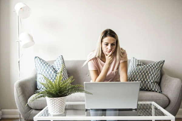 stock image woman with a laptop on sofa at home