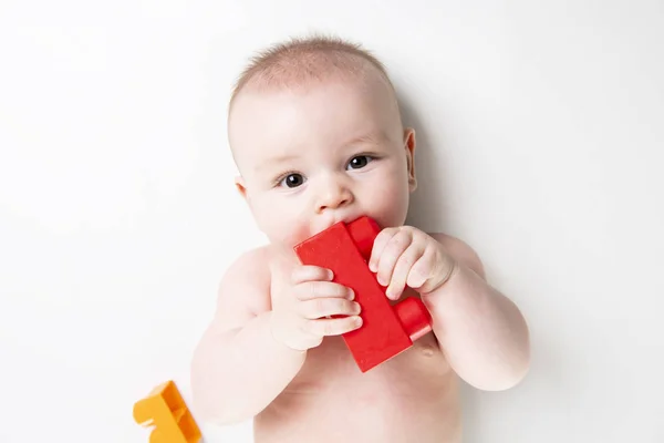 Baby boy plays with toy blocks over white background — Stock Photo, Image