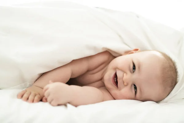 Feliz lindo bebé acostado en blanco hoja — Foto de Stock