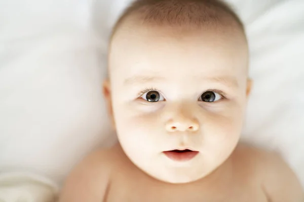 Heureux bébé mignon couché sur feuille blanche — Photo