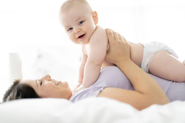 Mother lay on bed with his baby — Stock Photo, Image