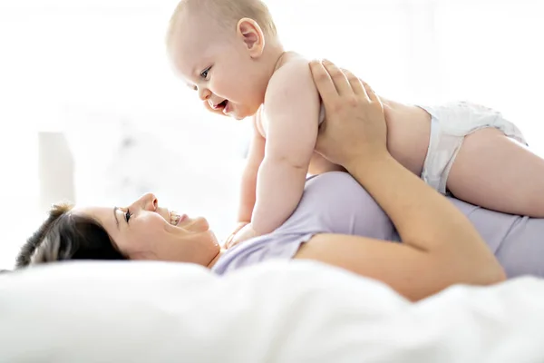 Mother lay on bed with his baby — Stock Photo, Image