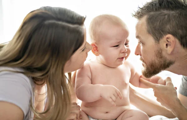 Madre padre e hijo bebé en una cama blanca. — Foto de Stock