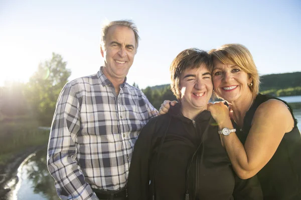 Pareja al aire libre con la persona con discapacidad hija por lago pasar un buen rato — Foto de Stock