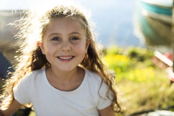 Outdoor portrait of adorable little girl next to lake at the sunset — Stock Photo, Image