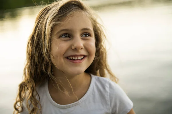 Roztomilé dítě dívka na dřevěné platformě u jezera. — Stock fotografie