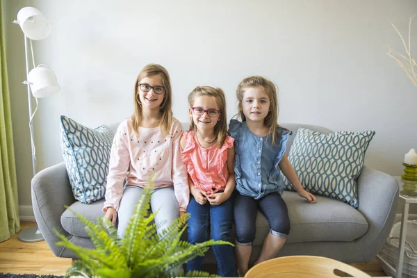 三姉妹の女の子が自宅のソファに座る — ストック写真
