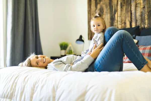 Mother and his baby daughter on bed having fun — Stock Photo, Image