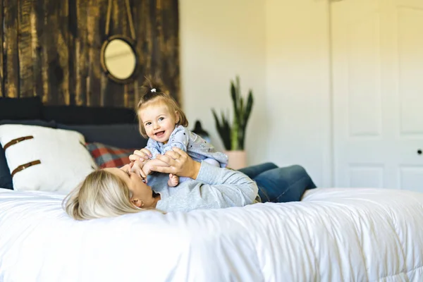 Mother and his baby daughter on bed having fun — Stock Photo, Image