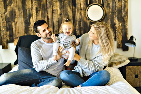 Familia en la cama con su bebé en la mañana — Foto de Stock