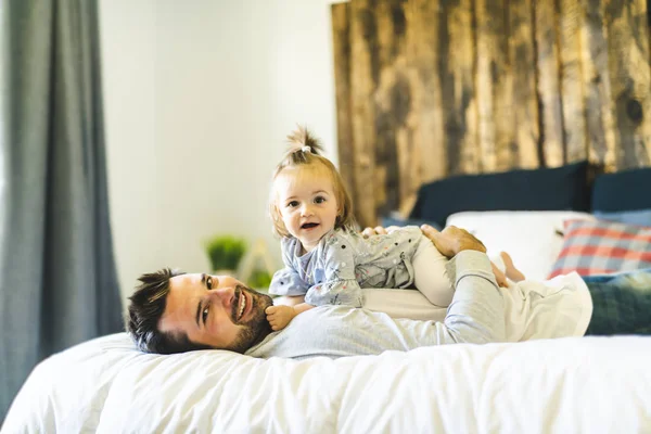 Padre y su hija bebé en la cama divertirse — Foto de Stock