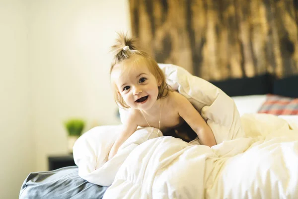 Petite fille mignonne sur le lit à la maison — Photo