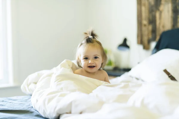Petite fille mignonne sur le lit à la maison — Photo