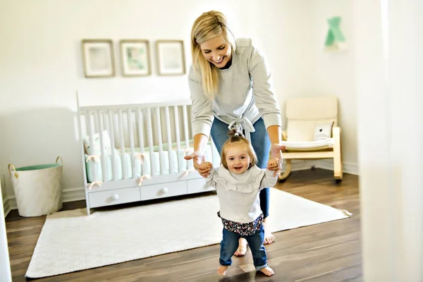 Little baby girl first steps with the help of mother — Stock Photo, Image