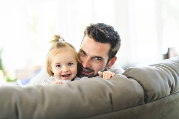 Jeune père avec bébé fille sur canapé à la maison — Photo