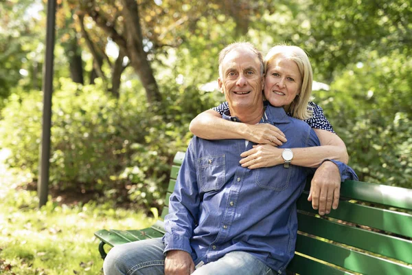 A Senior couple sitting on a park bench shallow depth of field — Stock Photo, Image