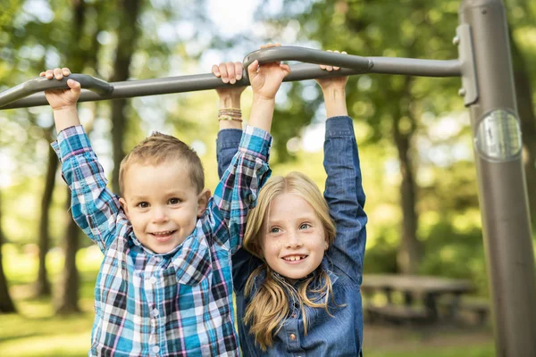 De två små barnen ha roligt på lekplatsen — Stockfoto