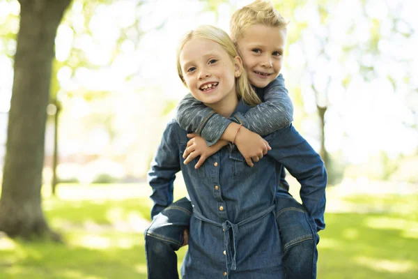 En bild av bror och syster har kul i parken — Stockfoto