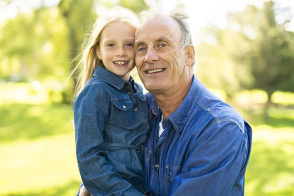 Großvater amüsiert sich mit Kleinkind im Park — Stockfoto