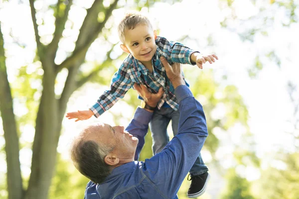 Grandfather and littleson having fun in the park — Stock Photo, Image