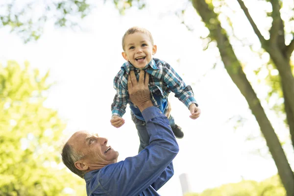 Grandfather and littleson having fun in the park — Stock Photo, Image