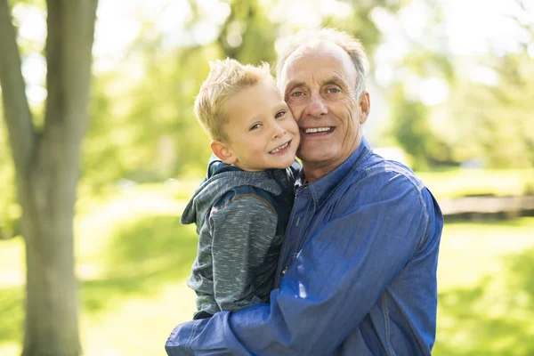 Großvater und kleiner Sohn amüsieren sich im Park — Stockfoto