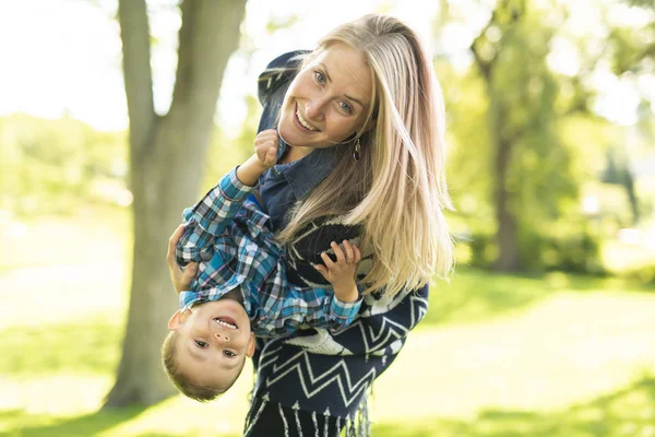 En mor med barn att ha roligt på en park — Stockfoto