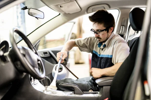 Homem no trabalho limpeza dentro do automóvel na lavagem de carro — Fotografia de Stock