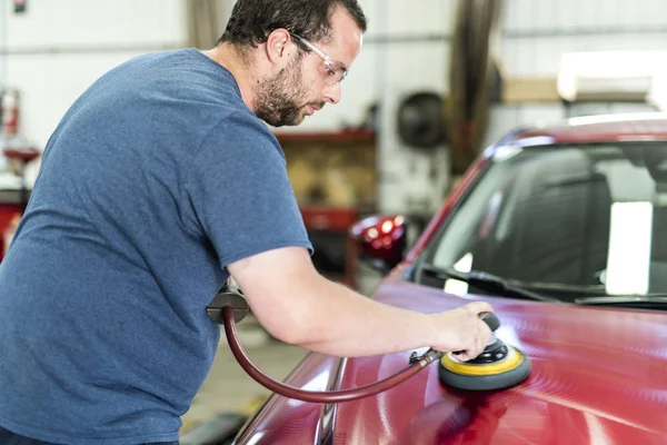 Człowiek w pracy sprzątanie samochodu na myjni samochodowej woskowej — Zdjęcie stockowe