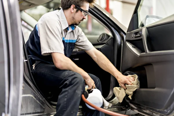 Homme au travail nettoyage à l'intérieur de l'automobile au lavage de voiture — Photo