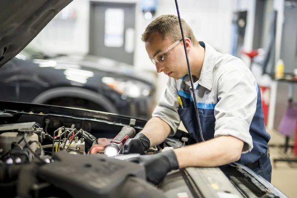 Stilig mekaniker jobb i uniform som arbetar på bil — Stockfoto