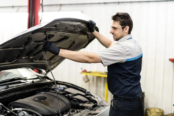 Schöner Mechaniker-Job in Uniform, der am Auto arbeitet — Stockfoto