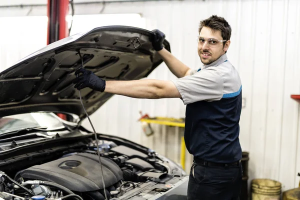 Beau travail de mécanicien en uniforme travaillant sur la voiture — Photo